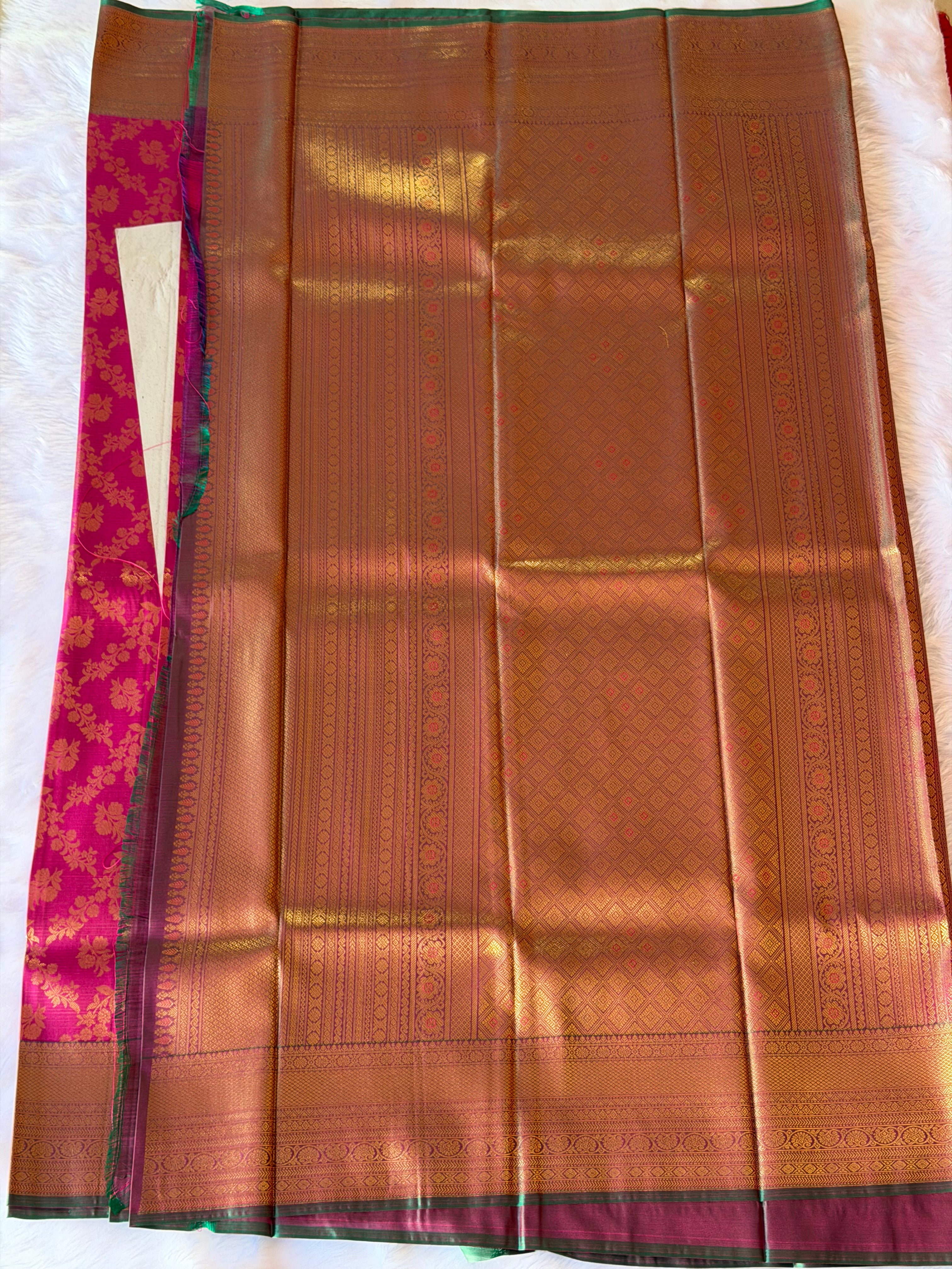 Wide gold-weave and emerald green border on vibrant magenta Kanchipuram polyester saree