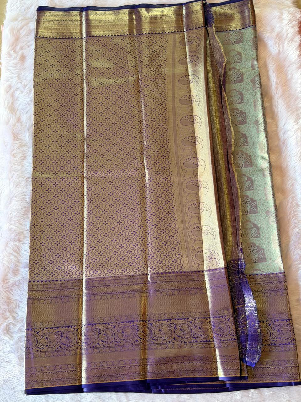 Pallu detail of sage green and purple Kanchipuram polyester saree with gold zari peacock motifs